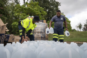 Workers with the Baltimore City Department of Public Works distribute jugs of water to city residents at the Landsdowne Branch of the Baltimore County Library on Sept. 6, 2022 in Baltimore, Maryland. The City of Baltimore issued a boil water advisory to over 1,500 residential and commercial facilities in West Baltimore after E. coli bacteria was found in drinking water. Credit: Drew Angerer/Getty Images