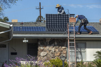Sunrun installers place solar panels on the roof of a home in Granada Hills, California. Credit: Mel Melcon / Los Angeles Times via Getty Images